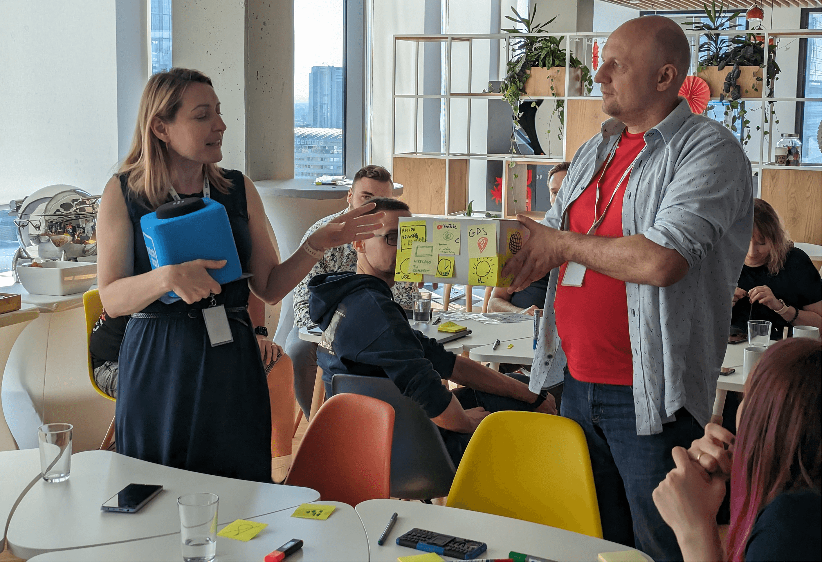 Workshop participants presenting cardboard radio designs to the room